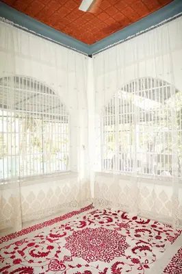 a room with two windows and a red and white rug at Dua farms in Sultan Bathery