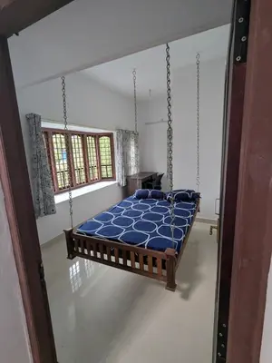 a bedroom with a swing bed in a room at Sankeerthanam - Lounge in serenity in Ernakulam