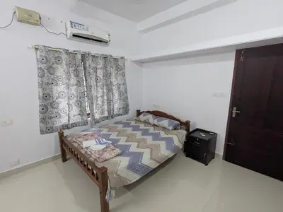 a bedroom with a bed with a curtain and a door at Sankeerthanam - Lounge in serenity in Ernakulam