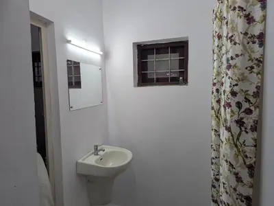 a white bathroom with a sink and a window at Sankeerthanam - Lounge in serenity in Ernakulam