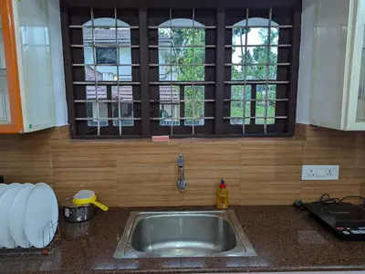 a sink in a kitchen with a window above it at Sankeerthanam - Lounge in serenity in Ernakulam
