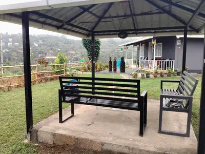a bench under a pavilion with a view of a house at Airin's Villa in Agali