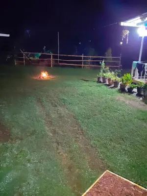 a backyard at night with a fire in the grass at Airin's Villa in Agali