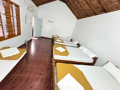 a room with a row of beds in it at Rafters Retreat Coorg - The Riverside Homestay in Srimangala
