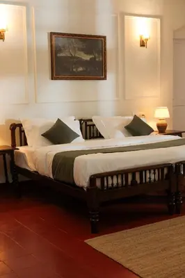 two twin beds in a bedroom with a picture on the wall at The Hundred House by Kisah Stays in Ambalavayal