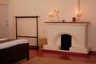 a room with a fireplace with candles on top of it at The Hundred House by Kisah Stays in Ambalavayal