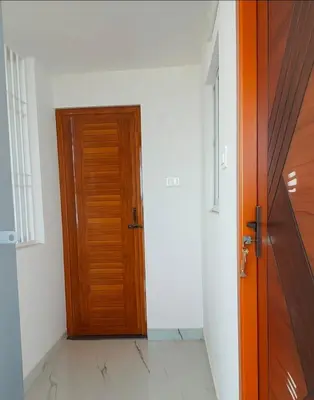 a wooden door in a room with a white wall at AR Homes in Coimbatore