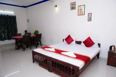 a bedroom with a bed and a dining room with a table at Coorg Holiday Homes in Madikeri