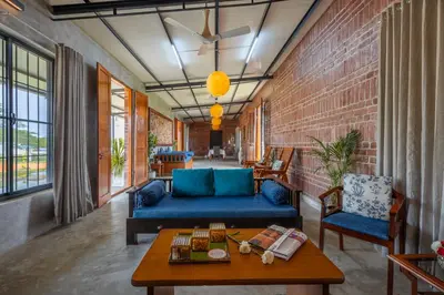 a living room with a blue couch and a table at amã Stays & Trails - Highland Breeze , Coimbatore in Coimbatore