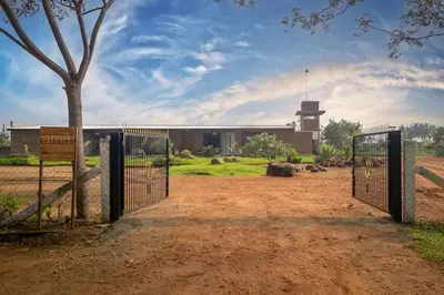 a gate in front of a building with a tree at amã Stays & Trails - Highland Breeze , Coimbatore in Coimbatore