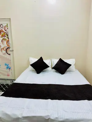 a bed with black and white pillows on it at Flats in city center, next to NEXUS MALL in Mysore