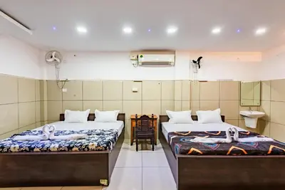 a room with two beds and a sink in it at Oxe residency in Kozhikode
