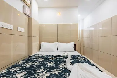 a small bedroom with a bed with a blue and white blanket at Oxe residency in Kozhikode