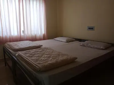 two twin beds in a room with a window at Villa 9 degrees north in Sultan Bathery