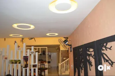 a living room with a ceiling with lights on it at Charis Villa in Kunnamkulam near Guruvayoor in Kunnamkulam