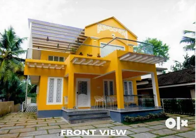 a yellow house with a front view of it at Charis Villa in Kunnamkulam near Guruvayoor in Kunnamkulam