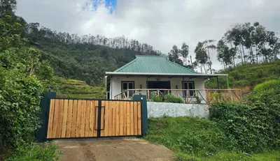 a house with a wooden gate in front of it at Bluehood WildScape in Vattavada