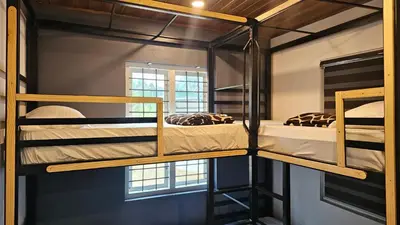 two bunk beds in a room with a window at Bluehood WildScape in Vattavada