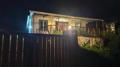 a house with a fence in front of it at night at Bluehood WildScape in Vattavada