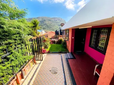 a house with a fence and a walkway at Skyline Haven cottage in Ooty