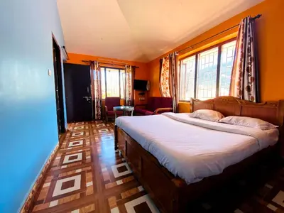 a bedroom with a bed with orange walls and windows at Skyline Haven cottage in Ooty