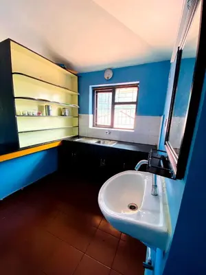 a blue bathroom with a sink and a window at Skyline Haven cottage in Ooty