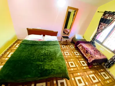 a bedroom with two beds and a mirror at Skyline Haven cottage in Ooty