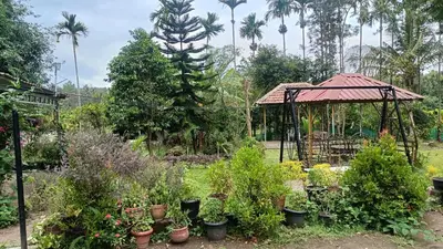 a garden with a gazebo and potted plants at Manna Homestay coorg in Kushālnagar