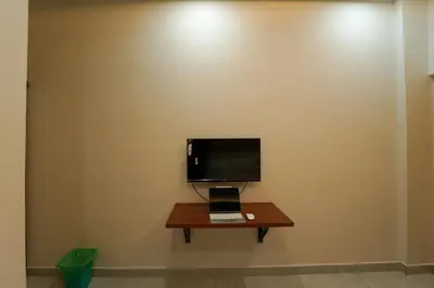 a desk with a laptop and a tv on a wall at SK Premium Residency in Edakkara