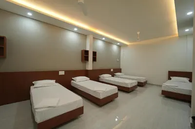 a hospital room with three beds and a tv at SK Premium Residency in Edakkara