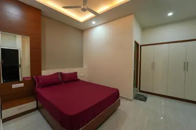 a bedroom with a red bed and a cabinet at SK Premium Residency in Edakkara