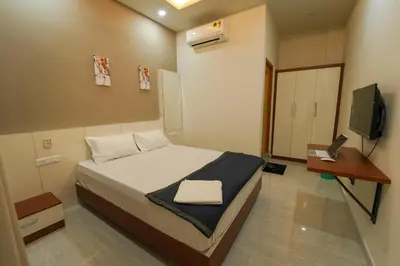 a small bedroom with a bed and a television at SK Premium Residency in Edakkara