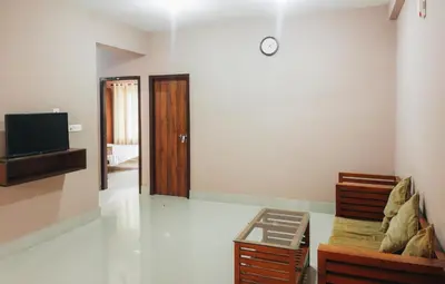 a living room with a couch and a tv at Fine Homes in Kalpetta
