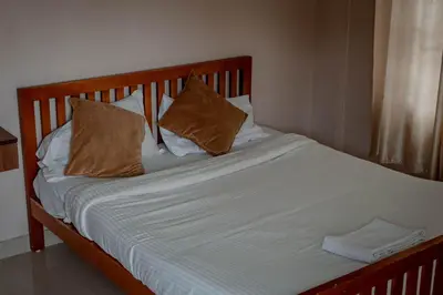 a bed with two pillows on top of it at Fine Homes in Kalpetta