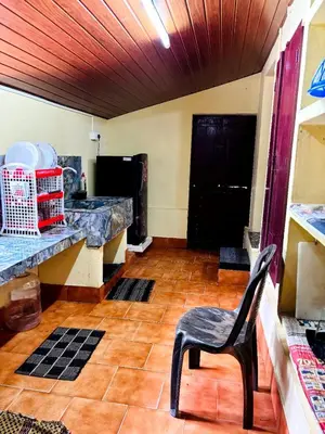 a kitchen with a table and a chair in a room at Edwin and Edrin Service Villa in Wayanad