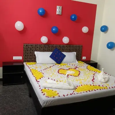 a bedroom with a bed with balloons on the wall at LIMRA INN RESIDENCY cottage in Ooty