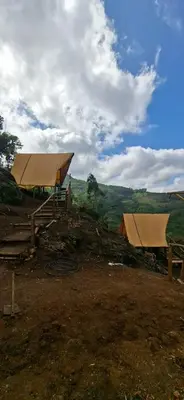 two tents sitting on top of a dirt field at Daddy's MAD house in Kottakamboor