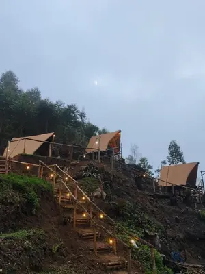 a group of tents on a hill with lights at Daddy's MAD house in Kottakamboor