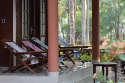 a row of deck chairs sitting on a porch at legacy beach stay kannur in Kannur