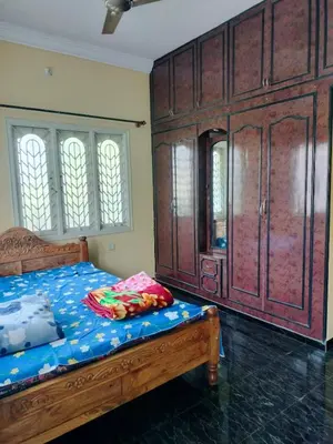 a bedroom with a bed and a large wooden cabinet at PG For Men in Mysore