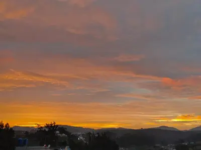 a sunset over a city with mountains in the background at Greenland 2bed room hall villa in Ooty