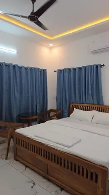 a bedroom with a bed and a blue curtain at The Paul Residence