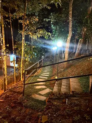 a fence with lights in a park at night at SURAAS Homestay Vythiri in Vythiri
