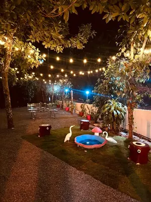a backyard at night with a pool and lights at SURAAS Homestay Vythiri in Vythiri