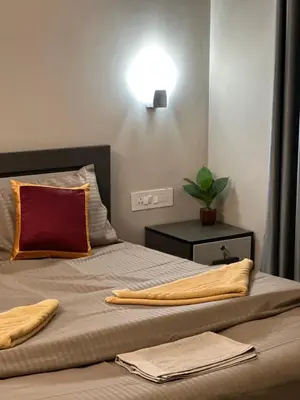a bedroom with a bed with two pillows on it at SURAAS Homestay Vythiri in Vythiri