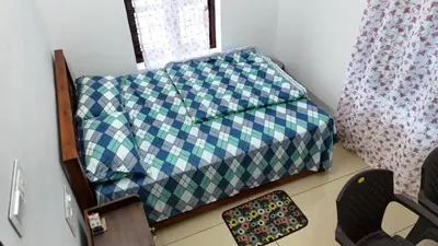 a bed with a blue and green checkered sheets in a room at Couples Nest in Kottakamboor