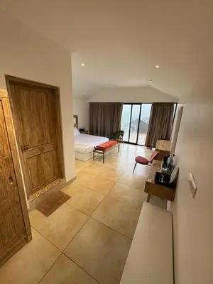 a bedroom with a bed and a room with a couch at Feliz by slowlane stays in Kotagiri
