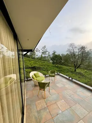 a view of a patio with a couch and chairs at Feliz by slowlane stays in Kotagiri