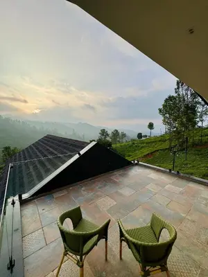 a patio with two chairs and a roof at Feliz by slowlane stays in Kotagiri