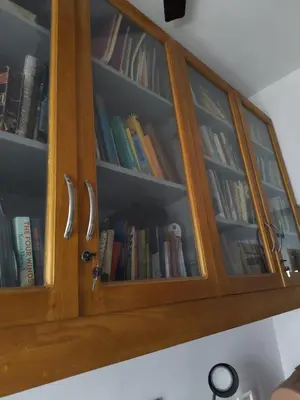 a wooden cabinet filled with lots of books at Retreat Rivera where Serenity Meets the River in Green Island